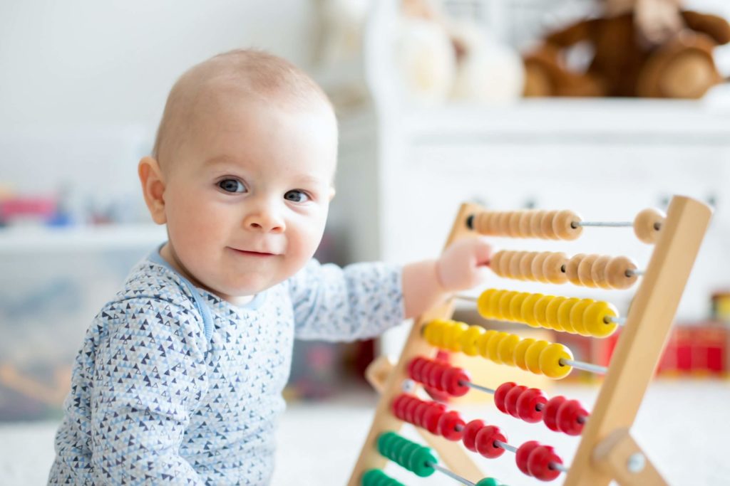 an infant plays with a abacus at a child care center