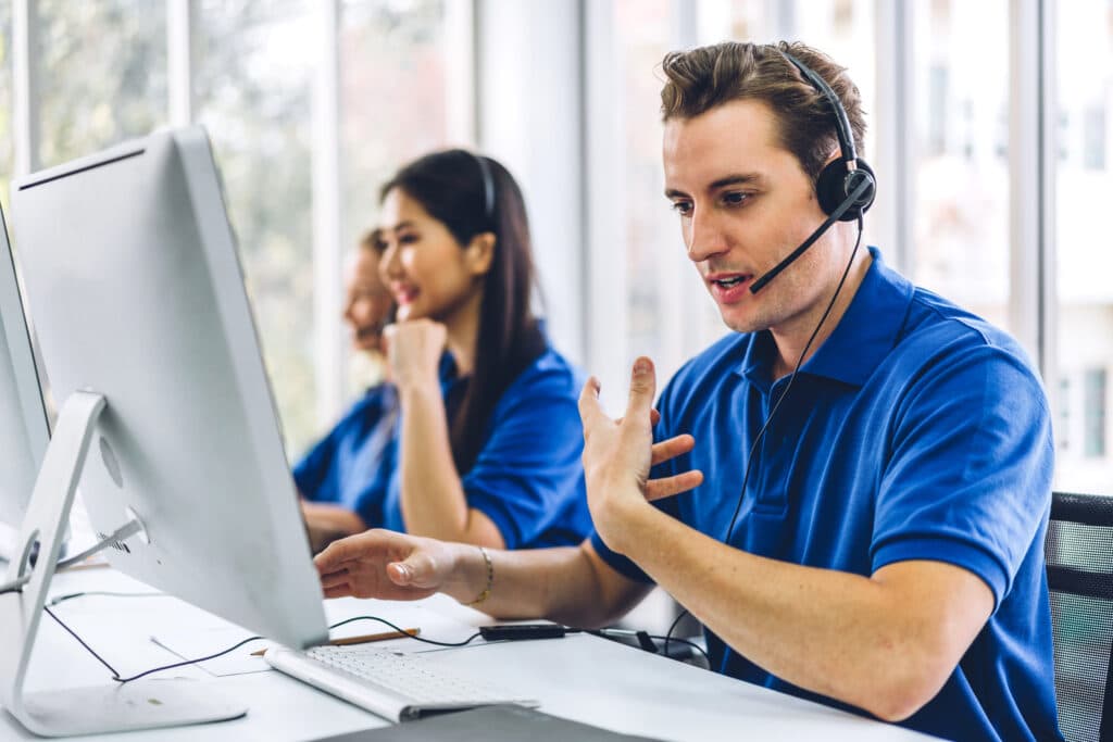 customer support agents take calls  at their computers
