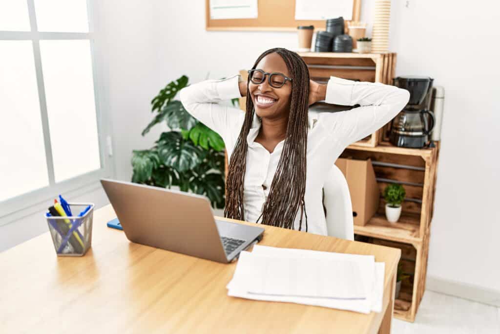 a woman sits grinning in front of her computer