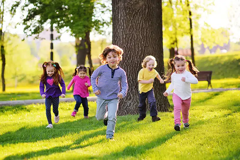 preschooler exercising by running across a field