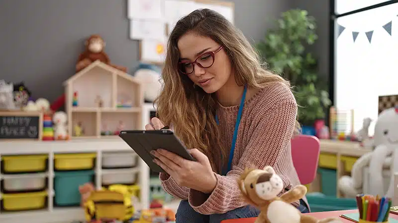 a teacher reviews an early childhood education assessment on a tablet