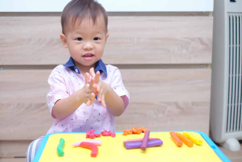 Baby plays with playdough as a sensory activity 