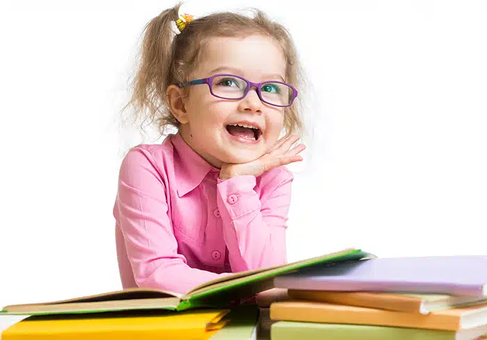 A preschool-age girl enjoys looking at books.