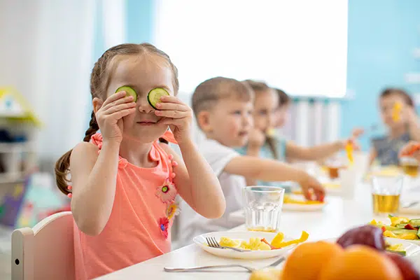 Girl eats cucumbers at lunch while in daycare