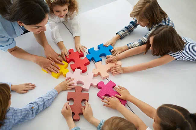 children play with a puzzle doing cooperative play
