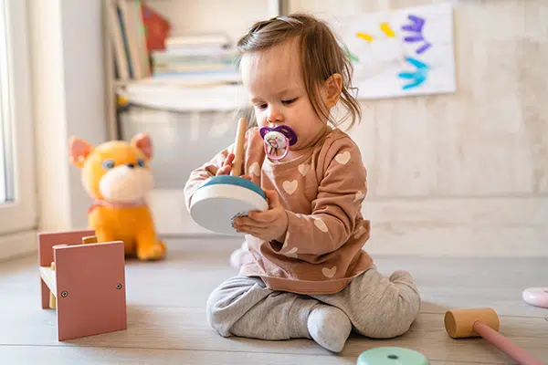 A baby takes part in solitary play, which fosters independence. 