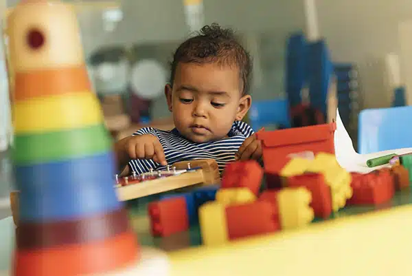 a child participates on solitary play with a xylophone and blocks