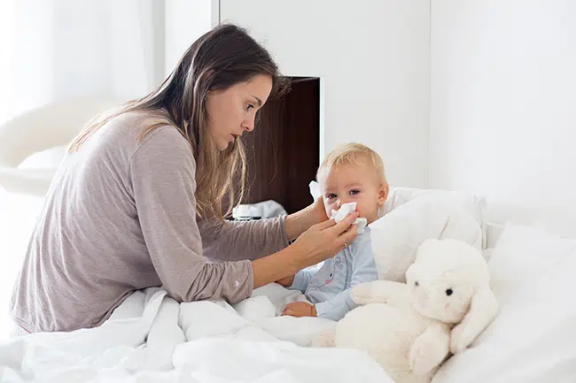 Mother cares for sick baby in bed