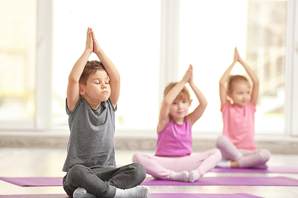 Children do yoga poses.