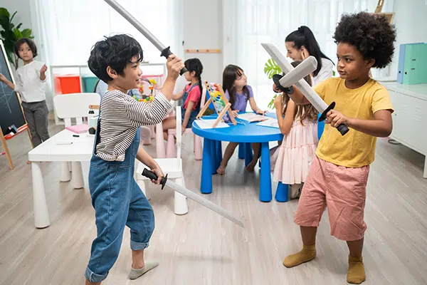 Preschoolers take part in sword role play game.