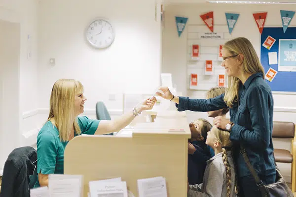 a woman makes a payment at the front desk of a daycare center