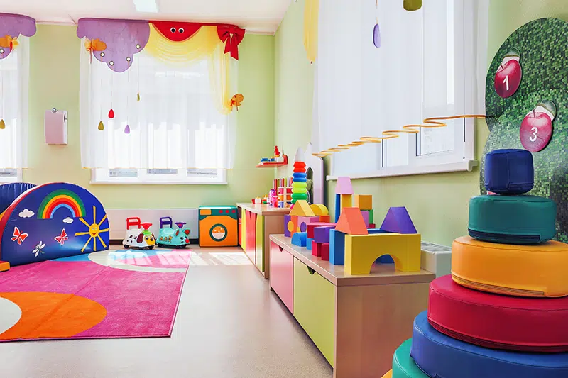 an empty but brightly let and well decorated preschool classroom