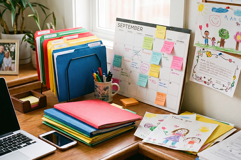 photo of a early childhood educators desk featuring a calendar filled with sticky notes